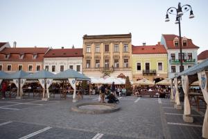 een stadsplein met tafels en parasols en een fontein bij Heart of the city in Braşov