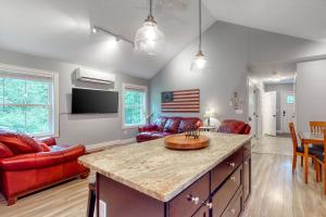 a kitchen and living room with red chairs and a table at Brown Moose Acres in Bridgton