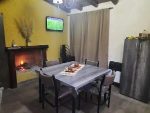 a dining room with a table and a fireplace at Cabaña El Manzano in Tunuyán