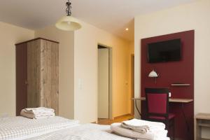a bedroom with two beds and a tv on the wall at Echinger Hof bei München in Eching +12 photos