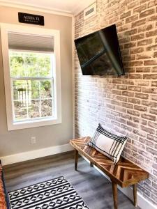 a living room with a bench and a brick wall at The Bobcat Cabin - The Cabins at Rim Rock in Austin