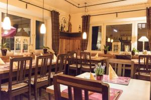 a restaurant with wooden tables and chairs and windows at Echinger Hof bei München in Eching