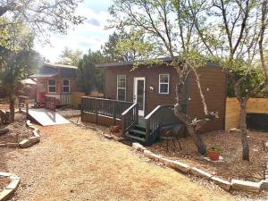 a small house with a porch and a yard at The Bobcat Cabin - The Cabins at Rim Rock in Austin