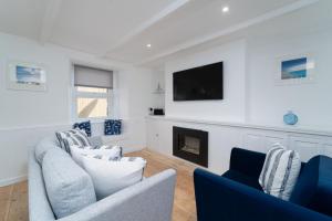 a living room with two couches and a fireplace at Karibu - Boutique Cottage with Parking - Short walk to Beach in St Ives