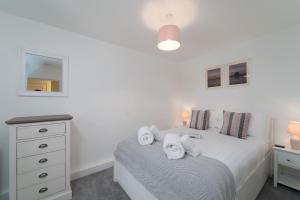a bedroom with a bed with towels on it at Karibu - Boutique Cottage with Parking - Short walk to Beach in St Ives
