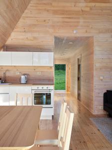 a kitchen and dining room with a wooden wall at 3kampai in Molėtai