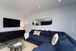 salon z niebieską kanapą i telewizorem z płaskim ekranem w obiekcie Surfside w mieście Hayle