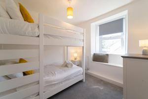 a bedroom with bunk beds and a window at Karibu - Boutique Cottage with Parking - Short walk to Beach in St Ives