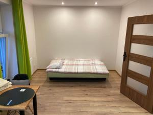 a room with a bed and a table and a door at Apartamenty Bezrzecze in Szczecin