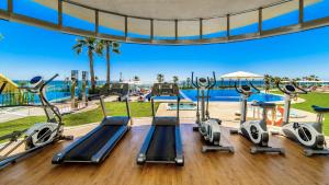 a gym with a view of the pool at a resort at Apartamento Sea Senses in Torrevieja