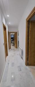 pasillo vacío con puertas de madera y suelo de baldosa en Riadh Andalous: Superbe S+2, en Ariana