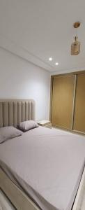 1 dormitorio con 1 cama blanca grande en una habitación en Riadh Andalous: Superbe S+2, en Ariana