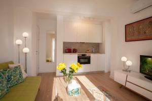 a living room with a couch and a vase of yellow flowers at Lovely beachfront apartment in Calahonda in Sitio de Calahonda