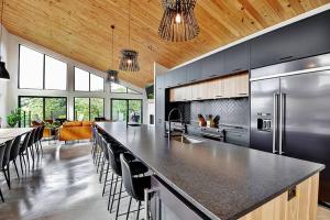 a large kitchen with a large island with black counter tops at Blanc 24 - Les Chalets Alpins, Stoneham in Stoneham
