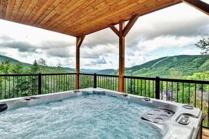 a hot tub on a balcony with mountains in the background at Blanc 24 - Les Chalets Alpins, Stoneham in Stoneham