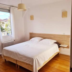 sypialnia z dużym białym łóżkiem i oknem w obiekcie Moulins F4 en centre ville Saint Dizier w mieście Saint-Dizier