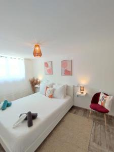 1 dormitorio con 1 cama blanca y 1 silla roja en Appartement 100m2, indépendant dans notre maison en Garennes-sur-Eure