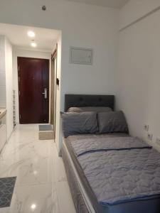 a bedroom with a bed in a room with a door at Precious Angel Apartment Sky House BSD in Pagedangan