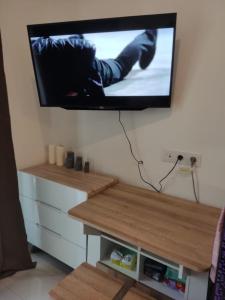 a flat screen tv hanging on a wall at Precious Angel Apartment Sky House BSD in Pagedangan