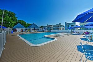 een zwembad met stoelen en blauwe parasols bij Ocean City Condo with Pool Access Walk to Beach! in Ocean City