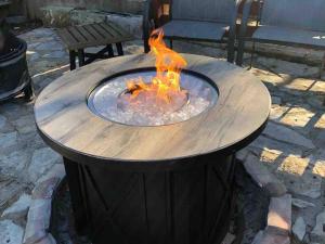 una mesa circular de madera con chimenea en Fox Tiny Home - The Cabins at Rim Rock en Austin
