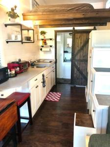 una pequeña cocina con fregadero y nevera. en Fox Tiny Home - The Cabins at Rim Rock en Austin