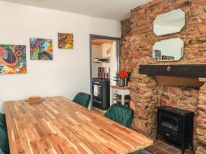 a dining room with a table and a stone fireplace at 25 Yon Street in Newton Abbot