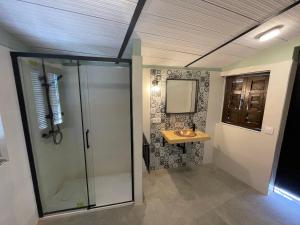 a bathroom with a glass shower and a sink at Caserío de Charca Cuca in Úbeda