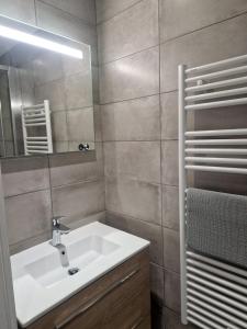 a bathroom with a sink and a mirror at Le Syma, en plein centre ville in Le Bourg-dʼOisans +8 photos