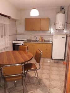 a kitchen with a table and chairs and a refrigerator at Casa sur 3 (faro norte) in Mar del Plata