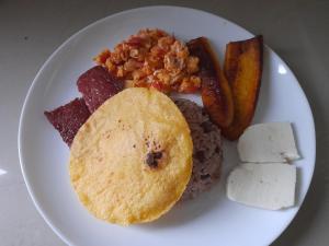 a plate of food with rice and meat and vegetables at Onca Tours & Treehouses in San Rafael