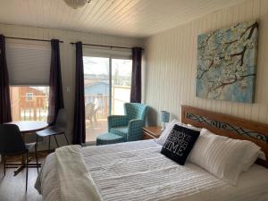 ein Schlafzimmer mit einem Bett und einem Tisch und Stühlen in der Unterkunft Merland Park Cottages and Motel in Picton + 119 Fotos