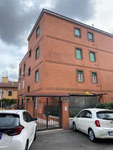 dos coches estacionados frente a un edificio de ladrillo en Casa Gemelli Home en Roma