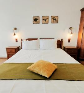 a bedroom with a white bed with a pillow on it at Pension Nea Marin in Măgura