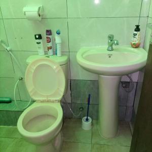 La salle de bains est pourvue de toilettes et d'un lavabo. dans l'établissement La Grande cosy studio apartment, à Mtwapa