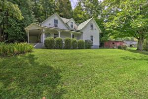 ein weißes Haus mit einem Garten mit grünem Gras in der Unterkunft Lil Red Hen Cottage in the Boone Area with Hot Tub in West Jefferson