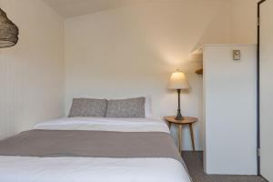 ein Schlafzimmer mit einem Bett und einer Lampe auf einem Tisch in der Unterkunft Mackenzie Beach Resort in Tofino