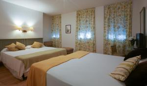 A bed or beds in a room at Hotel Alcántara