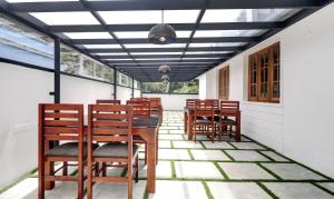 a dining room with chairs and a table on a patio at Itsy By Treebo - Palm Grove By D2V in Cochin