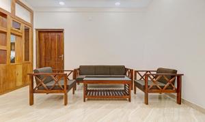 a living room with two chairs and a table at Itsy By Treebo - Palm Grove By D2V in Cochin