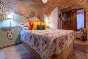 1 dormitorio con 1 cama grande y almohadas coloridas en AT La Habanera, en Cáceres