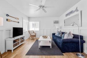 a living room with a blue couch and a tv at Newport Coastal Comfort in Newport Beach