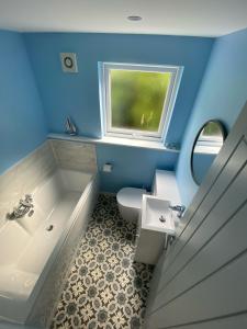 La salle de bains est pourvue d'une baignoire, d'un lavabo et de toilettes. dans l'établissement Brookbank Luxury 4 Bed House, à Teignmouth