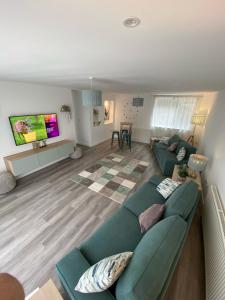 a living room with a couch and a tv at Brookbank Luxury 4 Bed House in Teignmouth