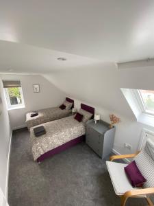 Cette chambre mansardée comprend un lit et un canapé. dans l'établissement Brookbank Luxury 4 Bed House, à Teignmouth