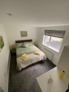 a small bedroom with a bed and a window at Brookbank Luxury 4 Bed House in Teignmouth