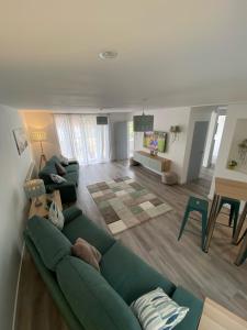 a living room with a green couch and a table at Brookbank Luxury 4 Bed House in Teignmouth