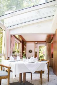 a dining room with a white table and chairs at Kurhotel Kaiser in Bad Wörishofen