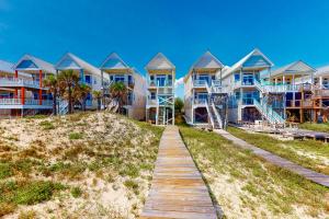 eine Reihe von Häusern am Strand mit Promenade in der Unterkunft A Sea Of Sand & Stars in St. George Island