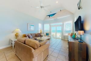 ein Wohnzimmer mit einem Sofa und einem TV in der Unterkunft A Sea Of Sand & Stars in St. George Island